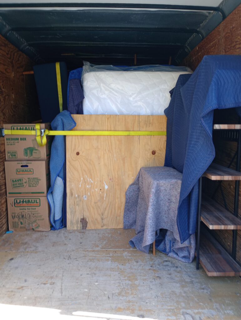 Items being loaded and tied down, towards the end of the trailer load.
